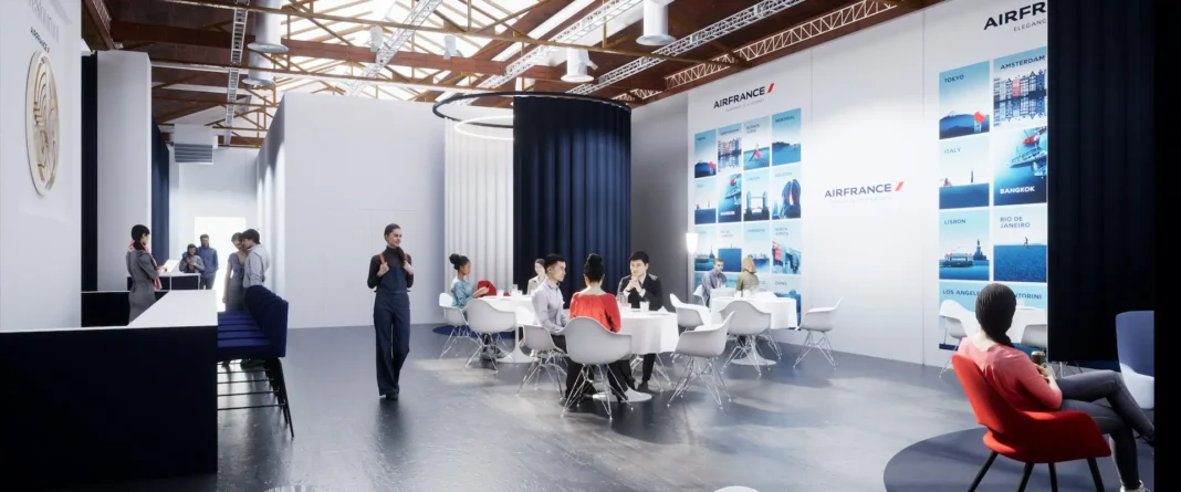 Um grupo de pessoas sentadas conversam em mesas dentro de um ambiente moderno e espaçoso, com tetos altos. A marca Air France decora as paredes de forma proeminente, evocando um toque de elegância parisiense. Em primeiro plano, alguém passa, trazendo um toque de calor de verão para a cena.